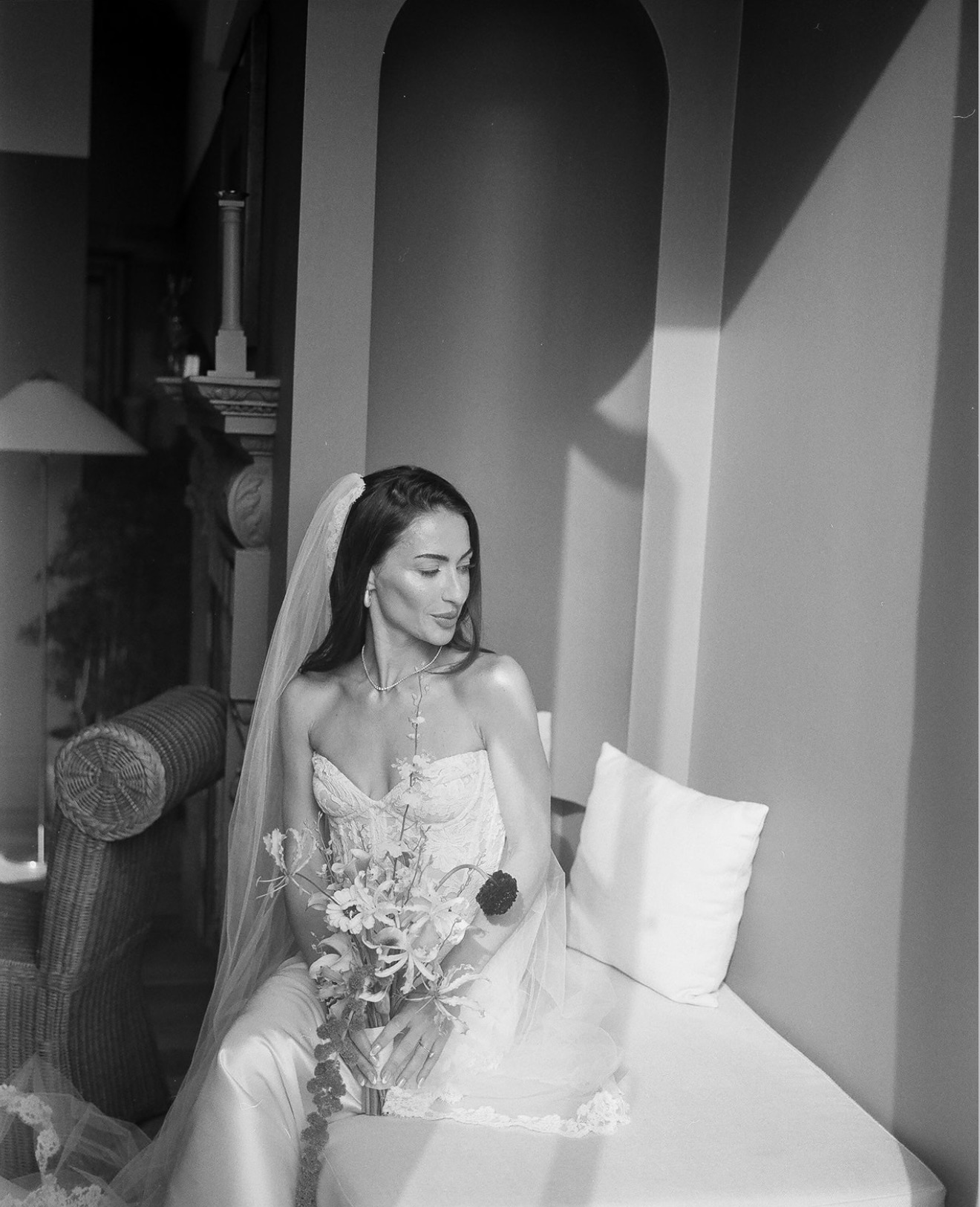 Black-and-white portrait of a seated bride holding her bouquet