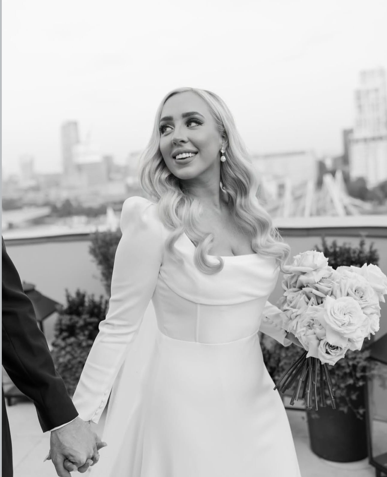 Bride with bouquet on London rooftop, B&W