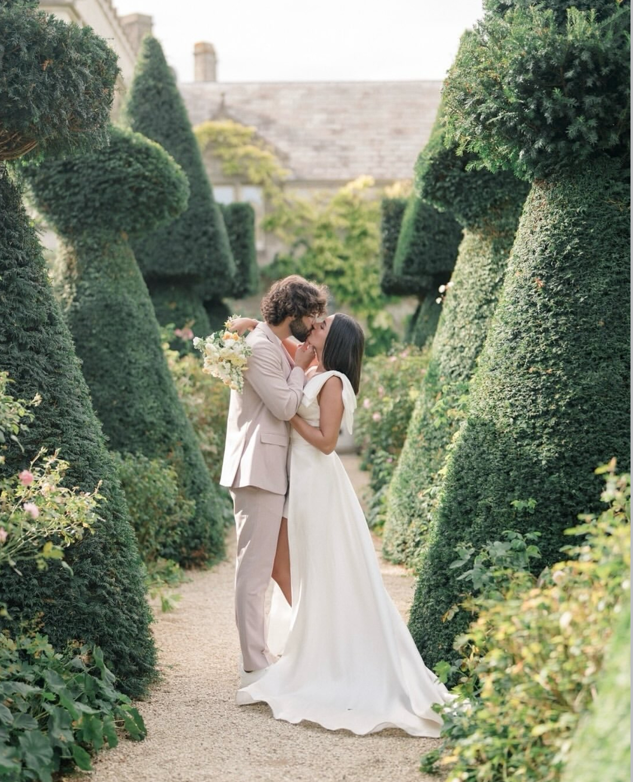 Couple kissing in topiary garden